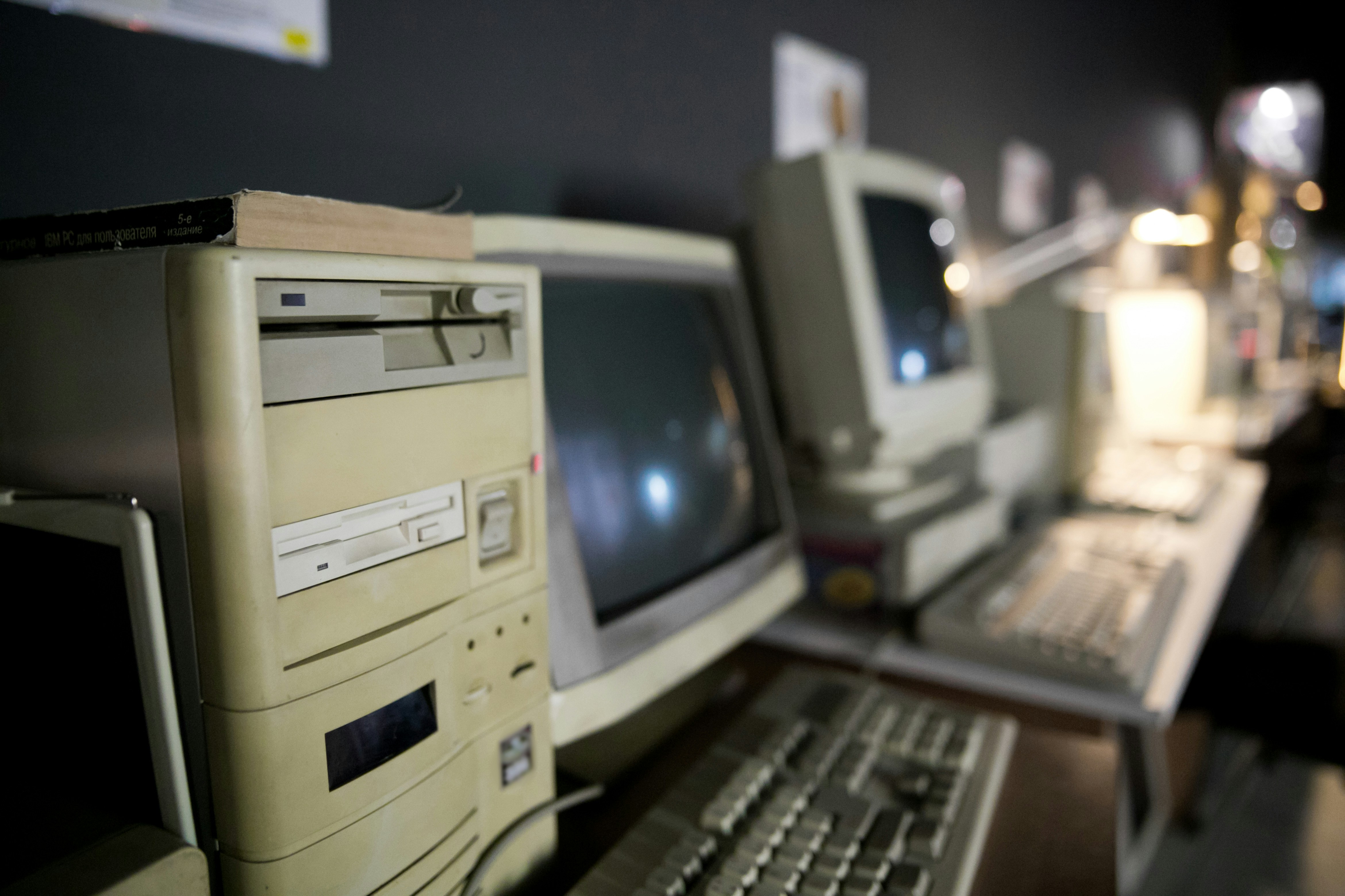 A vintage computer lab with bubble like screens and an old computer tower with CD and floppy drives.